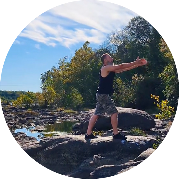 Steve doing an arm stretch while standing on rocks